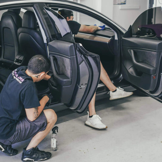 Image of employees working on an open car doing interior car detailing - sigma kore